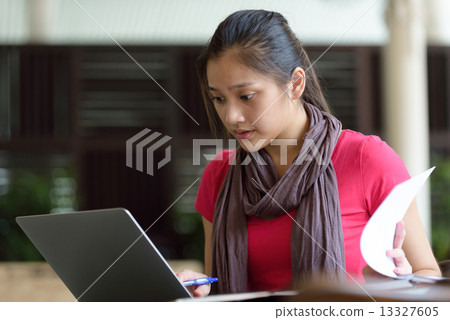 One young pan asian female student studying hard for examination in campus cafe One young pan asian female student studying hard for examination in campus cafe 13327605