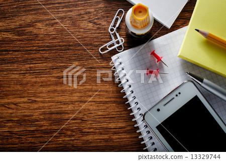 Educational Supplies and Phone on Wooden Table 13329744