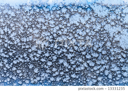 snowflakes and frost pattern on frozen window pane 13331235