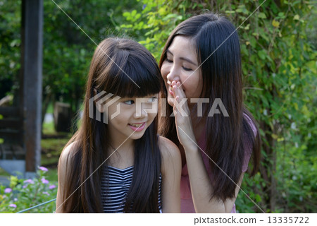 Mother and daughter sharing a secret 13335722