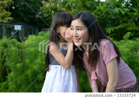 Mother and daughter sharing a secret 13335724