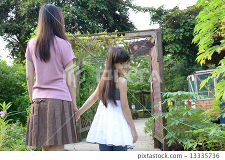 Mother and daughter in a garden (Back view) 13335736