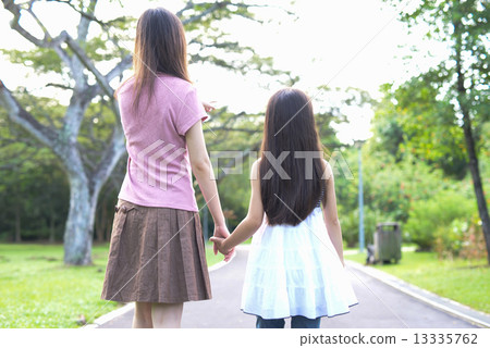 Mother and daughter walking in a park (back view) 13335762
