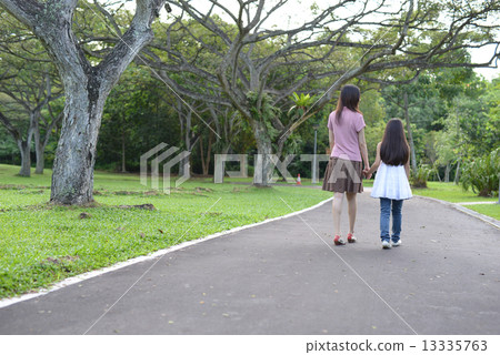 Mother and daughter walking in a park (back view) Mother and daughter walking in a park (back view) 13335763