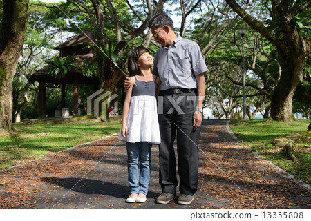 Grandfather and granddaughter strolling in the park Grandfather and granddaughter strolling in the park 13335808