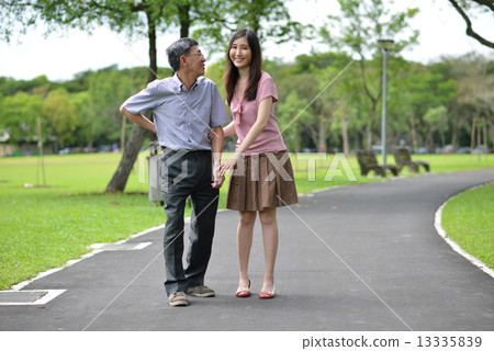 Aging father and daughter strolling in the park Aging father and daughter strolling in the park 13335839