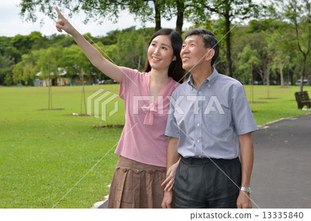 Aging father and daughter strolling in the park Aging father and daughter strolling in the park 13335840