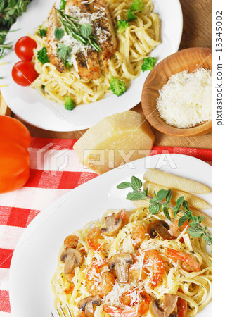 Pasta with shrimps and mashrooms on the wooden table Pasta with shrimps and mashrooms on the wooden table 13345002