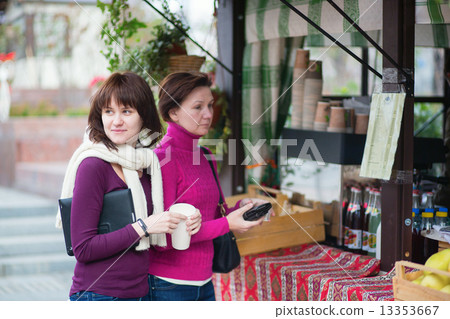 Mother and daughterbuying take away drinks Mother and daughterbuying take away drinks 13353667