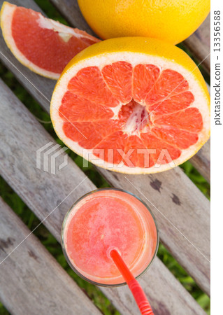 Pieces of grapefruit and a glass of fresh squeezed grapefruit ju Pieces of grapefruit and a glass of fresh squeezed grapefruit ju 13356588
