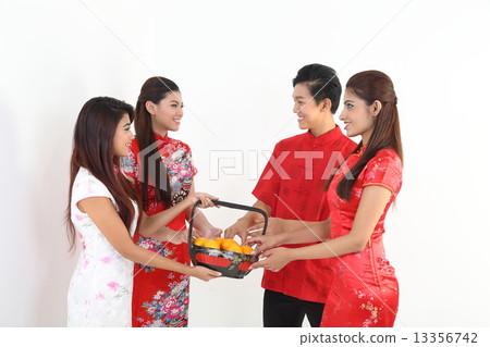 Man woman in traditional Chinese dress exchange New Year gift orange in basket CNY 13356742