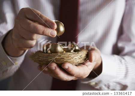 Businessman Holding Nest Full Of Golden Eggs 13361417