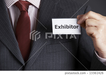 Businessman Attaching Exhibitor Badge To Jacket Businessman Attaching Exhibitor Badge To Jacket 13361426