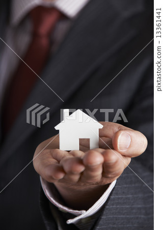 Businessman Holding Model House In Palm Of Hand 13361441