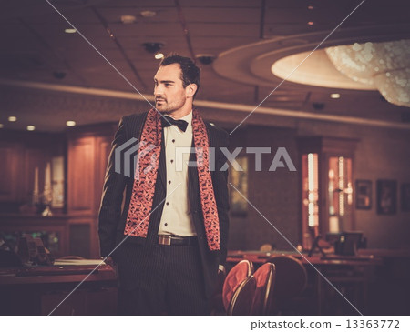 Handsome man wearing suit in luxury casino interior Handsome man wearing suit in luxury casino interior 13363772