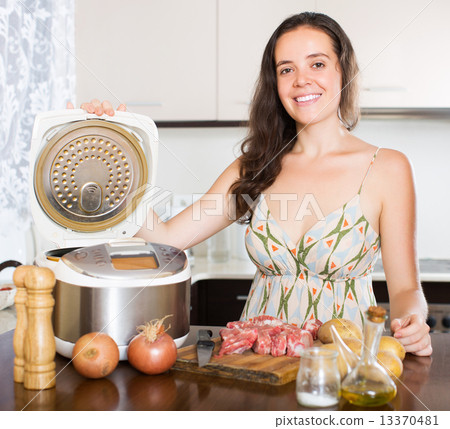 Housewife cooking meat with multicooker Housewife cooking meat with multicooker 13370481