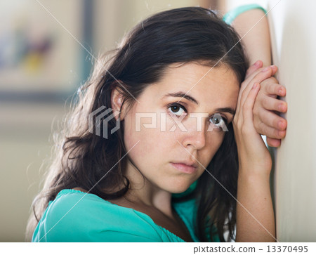 Crying woman against the wall 13370495