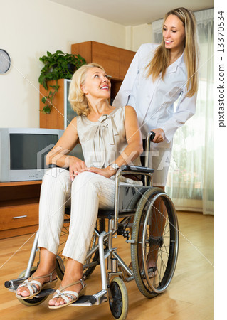 nurse and disabled woman on chair 13370534