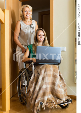 Happy girl in wheelchair working on laptop Happy girl in wheelchair working on laptop 13370646