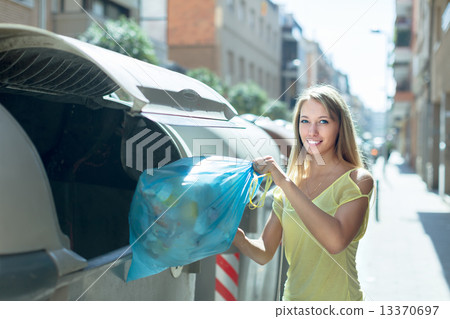 Woman with trash bags near garbage bin 13370697