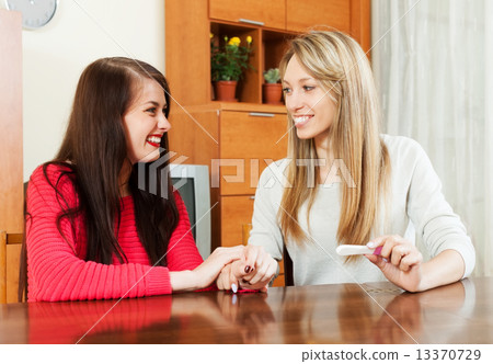Happy young women with pregnancy test Happy young women with pregnancy test 13370729