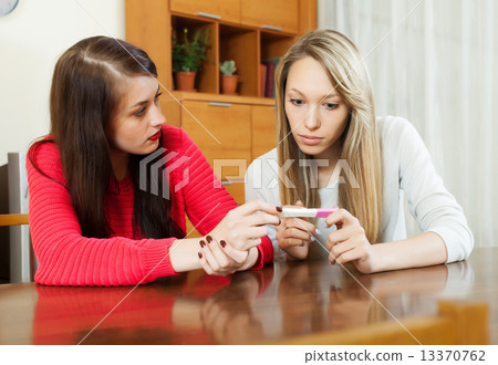 worried women with pregnancy test worried women with pregnancy test 13370762