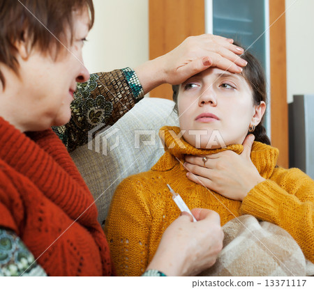 mature woman measuring temperature for cold adult daughter 13371117