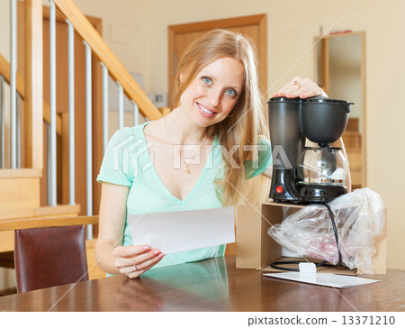 Woman with new electric coffee maker 13371210