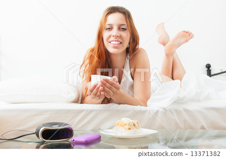 woman eating sweet cake and cafe at bed 13371382