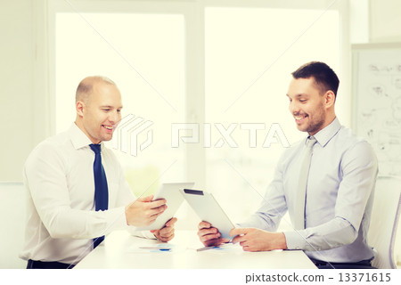 two smiling businessmen with tablet pc in office 13371615