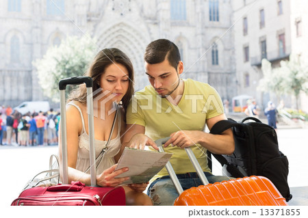 man and woman sitting near the baggage 13371855