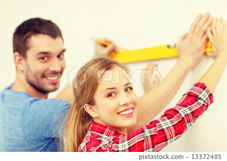 couple building using spirit level to measure 13372485