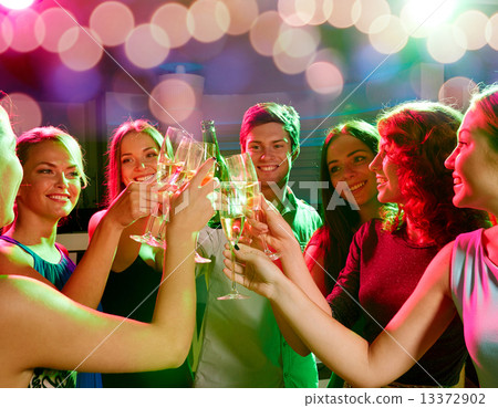 smiling friends with wine glasses and beer in club 13372902