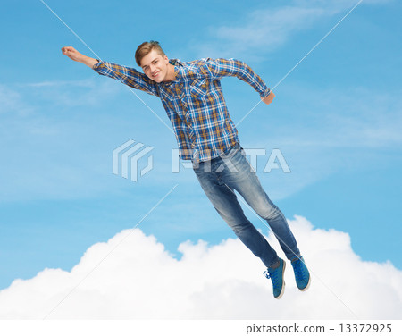 smiling young man jumping in air smiling young man jumping in air 13372925