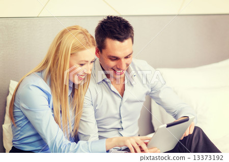 couple with tablet pc computer in hotel room 13373192