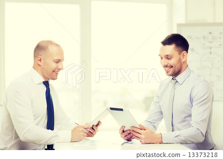 two smiling businessmen with tablet pc in office 13373218