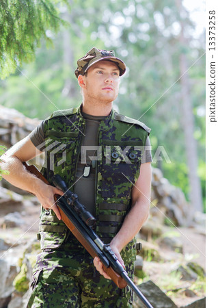 young soldier or hunter with gun in forest young soldier or hunter with gun in forest 13373258