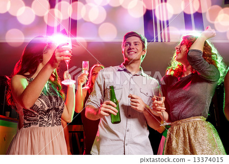 smiling friends with wine glasses and beer in club 13374015