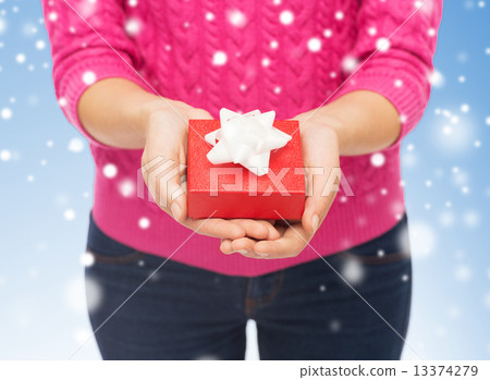 close up of woman in pink sweater holding gift box 13374279
