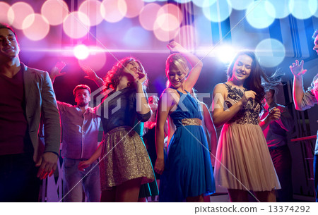 Stock Photo: smiling friends dancing in club