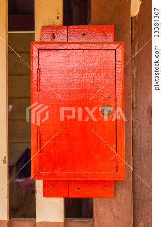 red wooden postbox on the wall 13384307