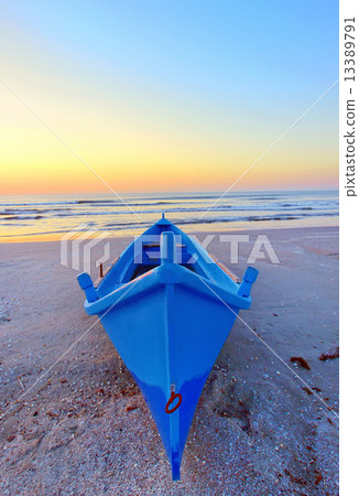 fishing boat on the seashore at sunrise 13389791