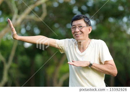 One male chinese elderly doing morning exercise in a park 13392926