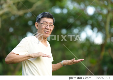 One male chinese elderly doing morning exercise in a park 13392997