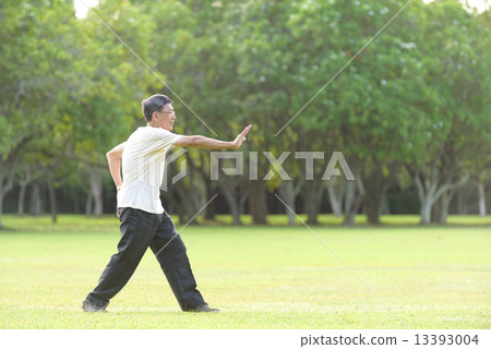 One male chinese elderly doing morning exercise in an open field in the park 13393004