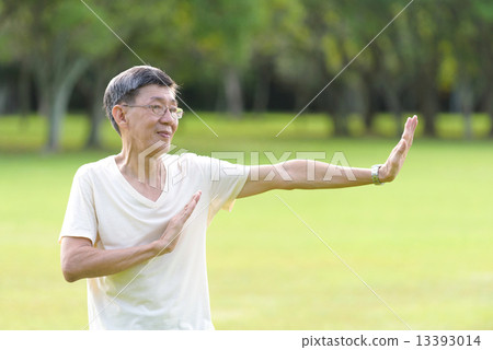One male chinese elderly doing morning exercise in an open field in the park 13393014
