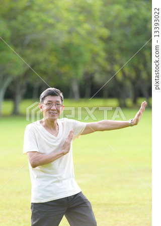One male chinese elderly doing morning exercise in an open field in the park 13393022