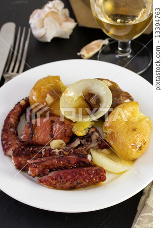 octopus with potato on the plate and glass of wine 13394763