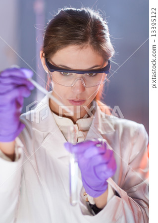Young scientist pipetting. Young scientist pipetting. 13395122