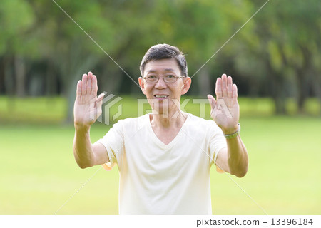 One male chinese elderly doing morning exercise in an open field in the park 13396184